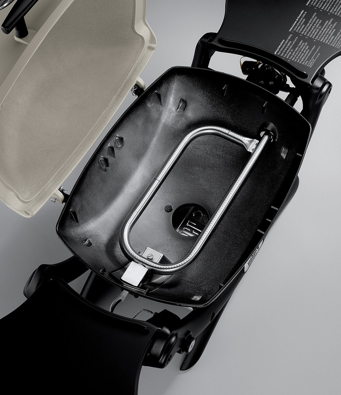 An open, black, hard-shell suitcase displaying an integrated tsa-approved combination lock mechanism in the interior, with a beige lining and an insert on the lid.