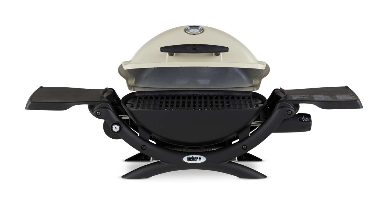 A portable Weber gas grill with a cream-colored lid, front-facing temperature gauge, black body, and two side tables designed for fire pit use, isolated on a white background.