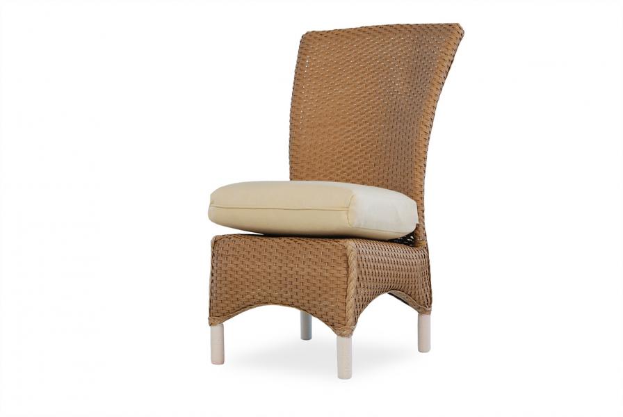 A high-backed wicker chair with a beige cushion beside a fireplace on a white background.