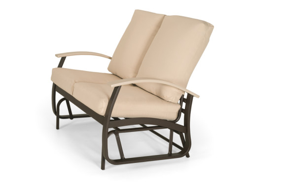 A comfortable beige cushioned reclining chair with a dark brown metal frame, isolated on a white background near a fireplace.