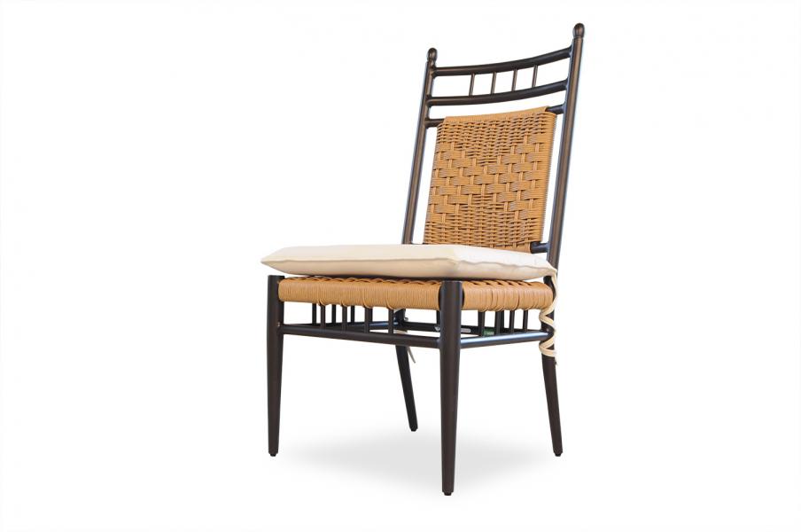 A stylish chair with a black wooden frame and woven rattan backrest, accompanied by a light beige cushion on the seat and an elegant fireplace insert, isolated on a white background.