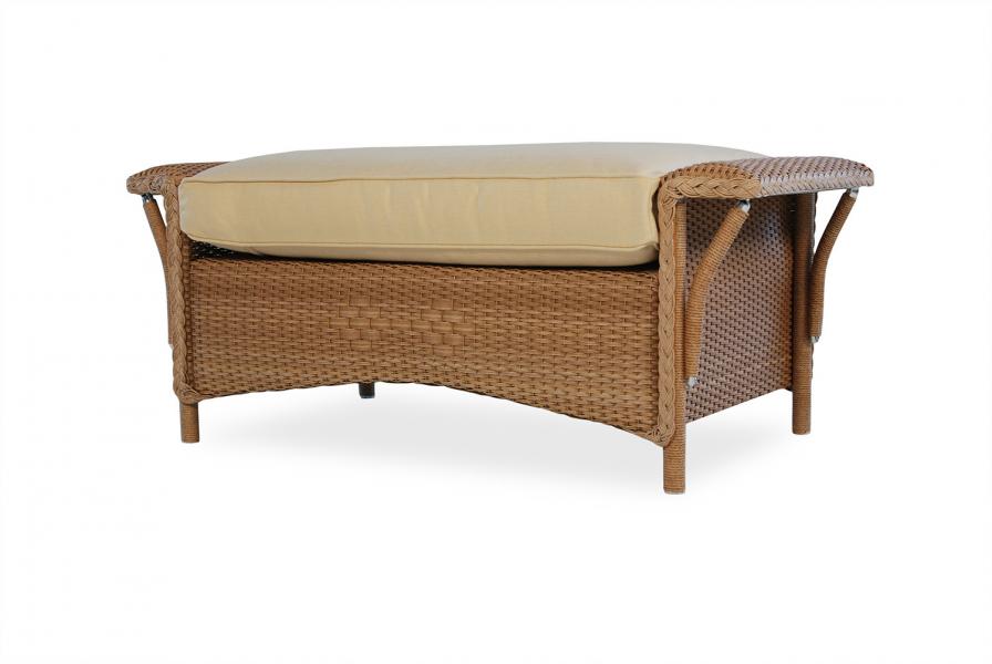 A wicker storage ottoman with a cushioned top on a white background. The ottoman is designed with a weave pattern and has dual functionality for sitting and storage, featuring an insert for additional functionality
