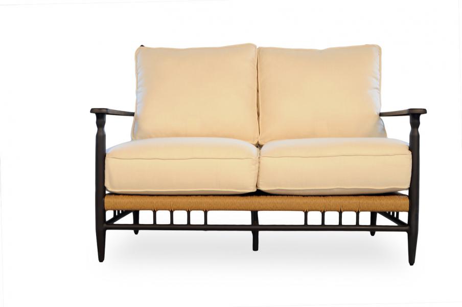 A two-seater sofa with a black wooden frame and light beige cushions, set near a fireplace, against a white background.