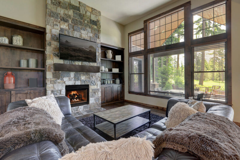 Accelerator wood fireplace by Heat & Glo in Black with Bi-Fold Glass doors with blue stone masonry in a living room
