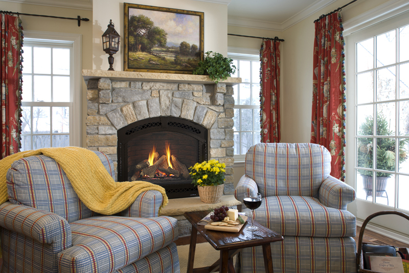 Cerona gas fireplace by Heat & Glo in black against a tan stone masonry hearth in a living room