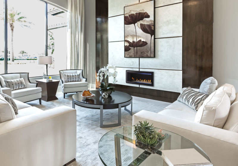 Cosmo Series gas fireplace by Heat & Glo in black with Clean Face front against a white marble pattern hearth