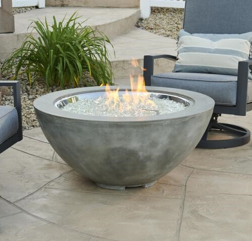 Cove Collection round gas fire pit with Natural Grey Supercast concrete in an outdoor living space near patio furniture