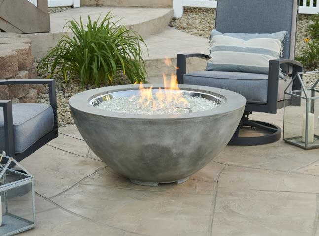Cove Collection round gas fire pit with Natural Grey Supercast concrete in an outdoor living space near patio furniture