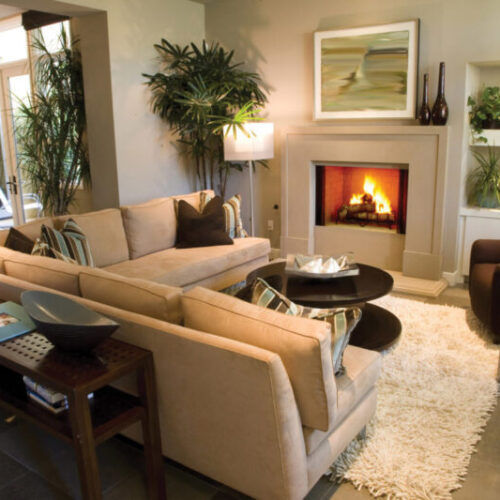 Exclaim Series wood fireplace by Heat & Glo in Black with Bi-Fold Glass doors with a white surround in a living room