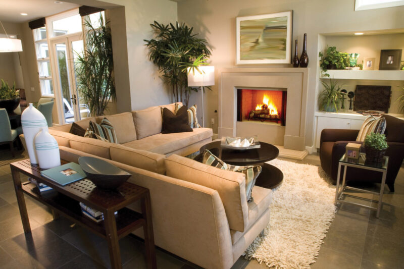 Exclaim Series wood fireplace by Heat & Glo in Black with Bi-Fold Glass doors with a white surround in a living room