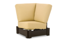 A modern yellow armchair with a high backrest and dark brown wooden legs, isolated on a white background near a fireplace insert.