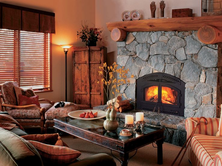 Northstar wood fireplace by Heat & Glo in black with blue stone masonry and hearth in a rustic living room