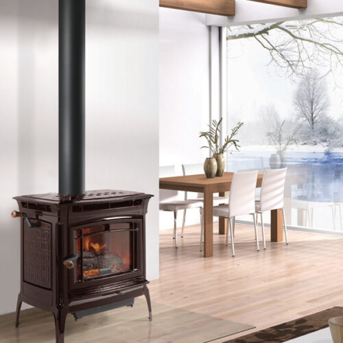A cozy room with a lit wood-burning stove, modern furniture, and large windows showcasing a snowy landscape outside. the room has a serene and warm ambiance.
