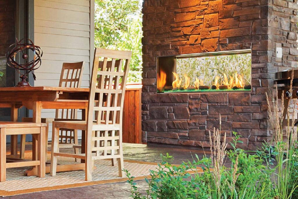 Lanai 48-inch see-through outdoor gas fireplace by Outdoor Lifestyles with dark brown stone hearth in modern patio