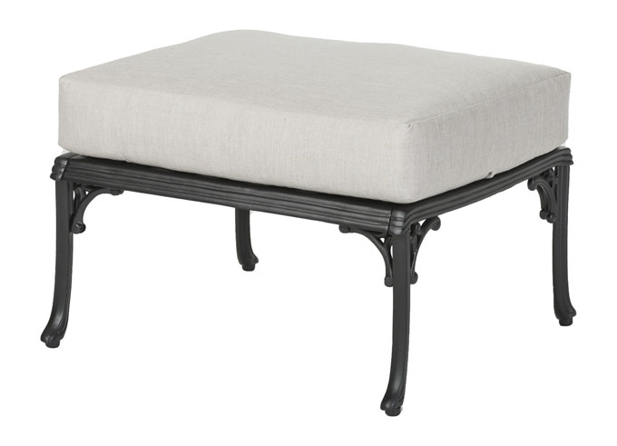 A square ottoman with a Gensun Michigan light beige cushion atop a black metal frame with ornate legs.