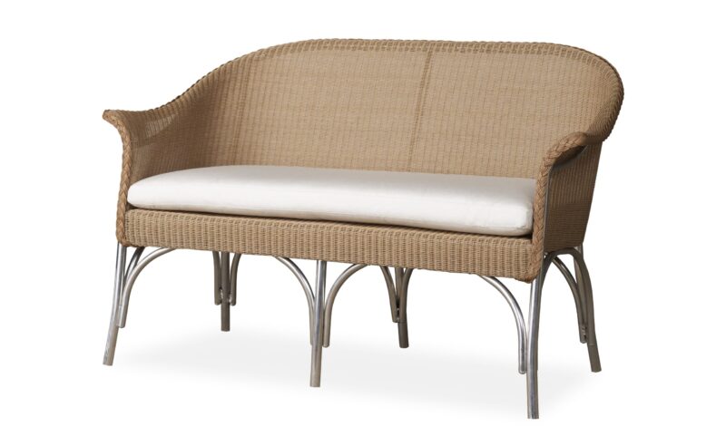 A wicker loveseat with a single white cushion on a frame of curved metal legs, isolated on a white background.