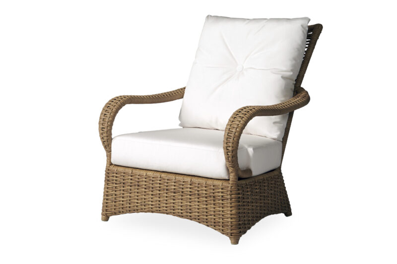 A wicker armchair with thick, white cushions against a white background.