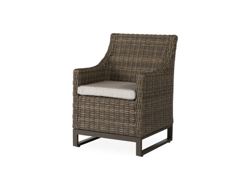 A modern wicker armchair with a dark brown tone and a contrasting light gray cushion on a simple black metal frame, isolated on a white background.
