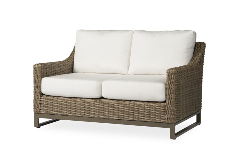 A stylish two-seater outdoor sofa with a brown wicker frame and white cushions on a white background.
