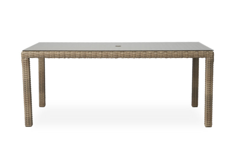 A rectangular outdoor dining table made of woven synthetic rattan with a glass top, set against a white background.