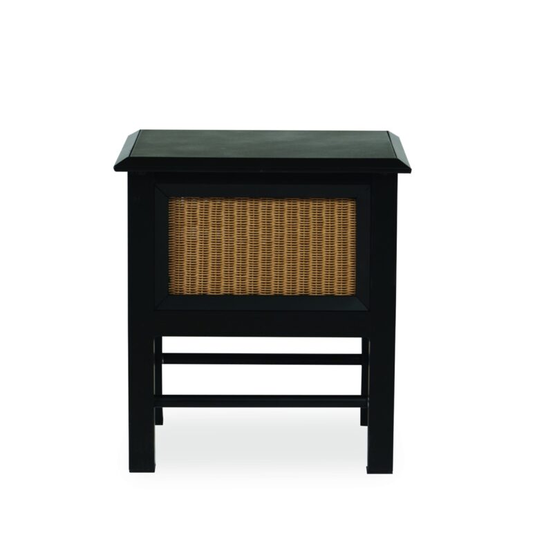 A black wooden side table with a woven rattan panel in the front, isolated on a white background. the table has a flat top and a lower shelf supported by four legs.