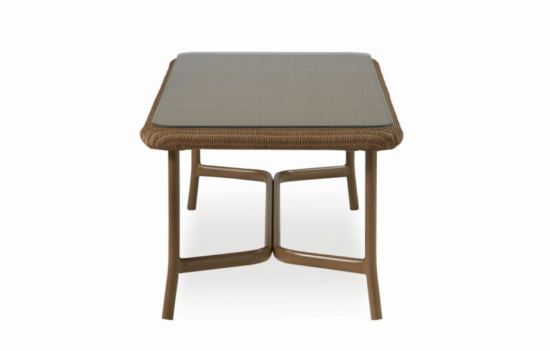 A square rattan coffee table with a textured top and angular legs, isolated on a white background.