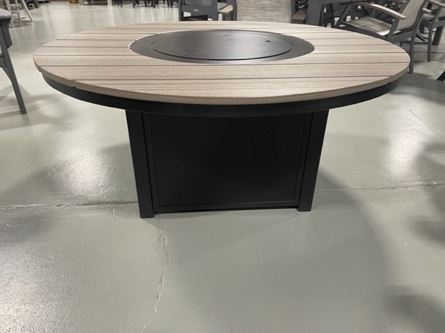 Round table with a two-toned striped tabletop and a central black turntable, supported by a solid black base, surrounded by Newport Adirondack Chairs, sitting on a gray concrete floor in an