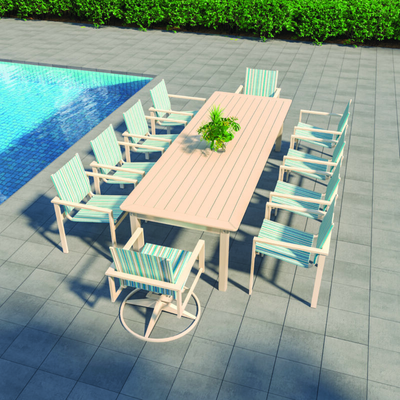 An outdoor dining setup by a pool, featuring a long table with a small plant centerpiece, surrounded by multiple chairs with blue and white striped cushions.