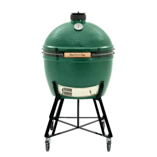 A The Big Green Egg grill, featuring a large, green, egg-shaped ceramic body with a temperature gauge on top, mounted on a black metal stand.