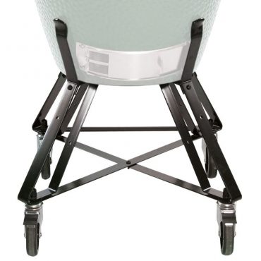 A large light green ceramic egg-shaped grill installed on a foldable metal stand with sturdy legs, viewed from a low angle facing the rear undercarriage.