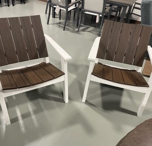 Two adirondack chairs with white frames and brown slatted seats and backs, positioned on a gray floor in an indoor setting.