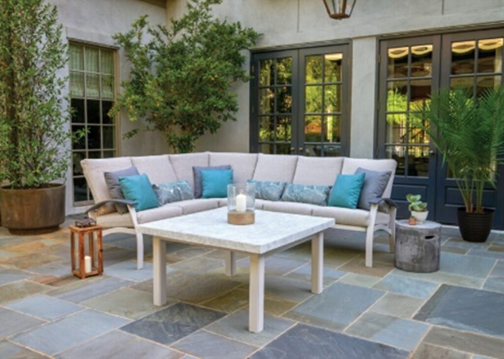 cream-colored telescope sectional on a slate floor, potted greenery, and attractive accessories
