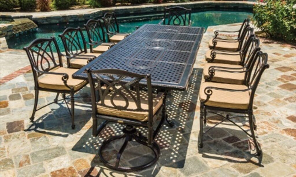 Gensun Grand Terrace dining table with 10 chairs, beige cushions, stone tile, pool in background