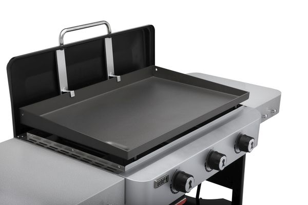 A Weber 28" stainless steel outdoor griddle with two control knobs and an open lid, isolated on a white background.