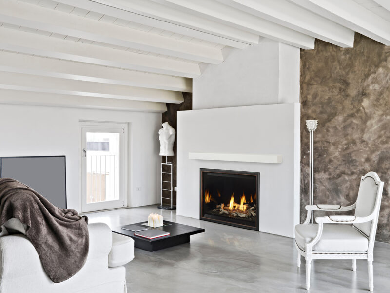 Modern living room with white furniture, a sleek fireplace, exposed beams on the ceiling, and a mix of smooth and textured walls.