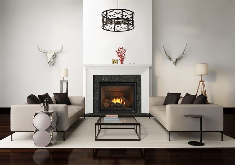 Modern living room with two cream sofas, a sleek coffee table, and a Heat & Glo 6K/8K Series Gas Fireplace. Decor includes a chandelier, wall-mounted animal skulls, and