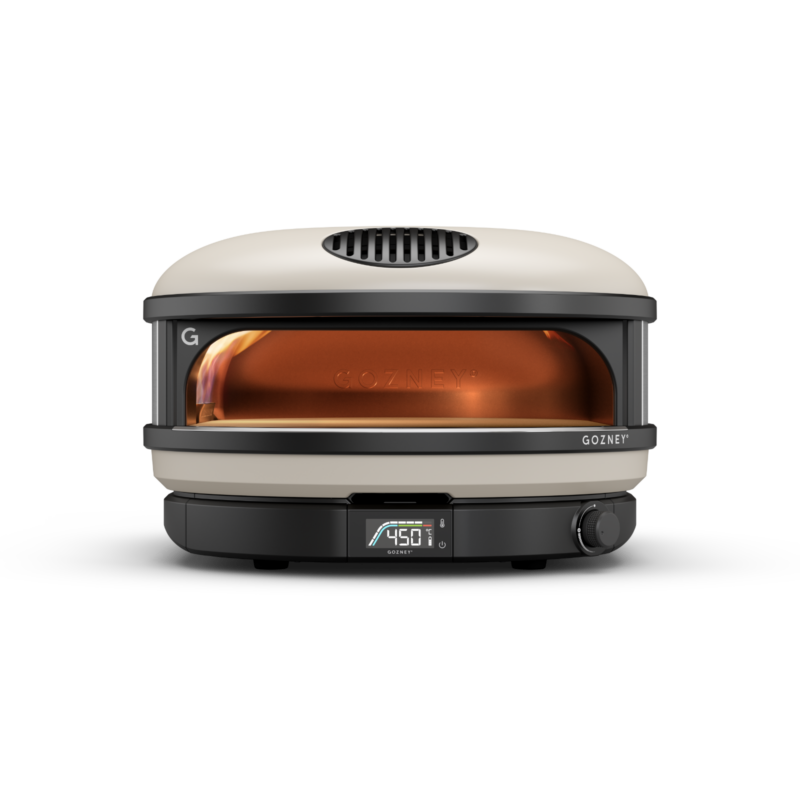 A gozney dome outdoor pizza oven in silver and black, displaying a temperature of 450°f, with visible flames inside.