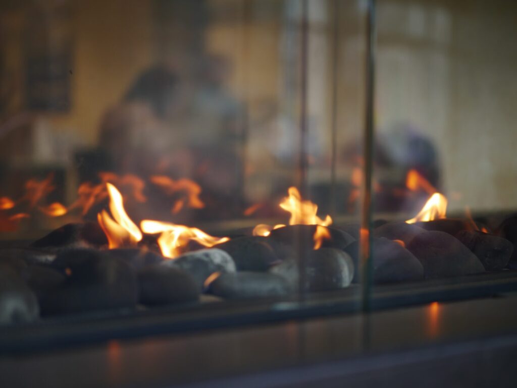 A close up of a lit modern gas fireplace for an indoor room